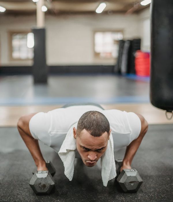 Man performing a controlled dumbbell press with intense focus.